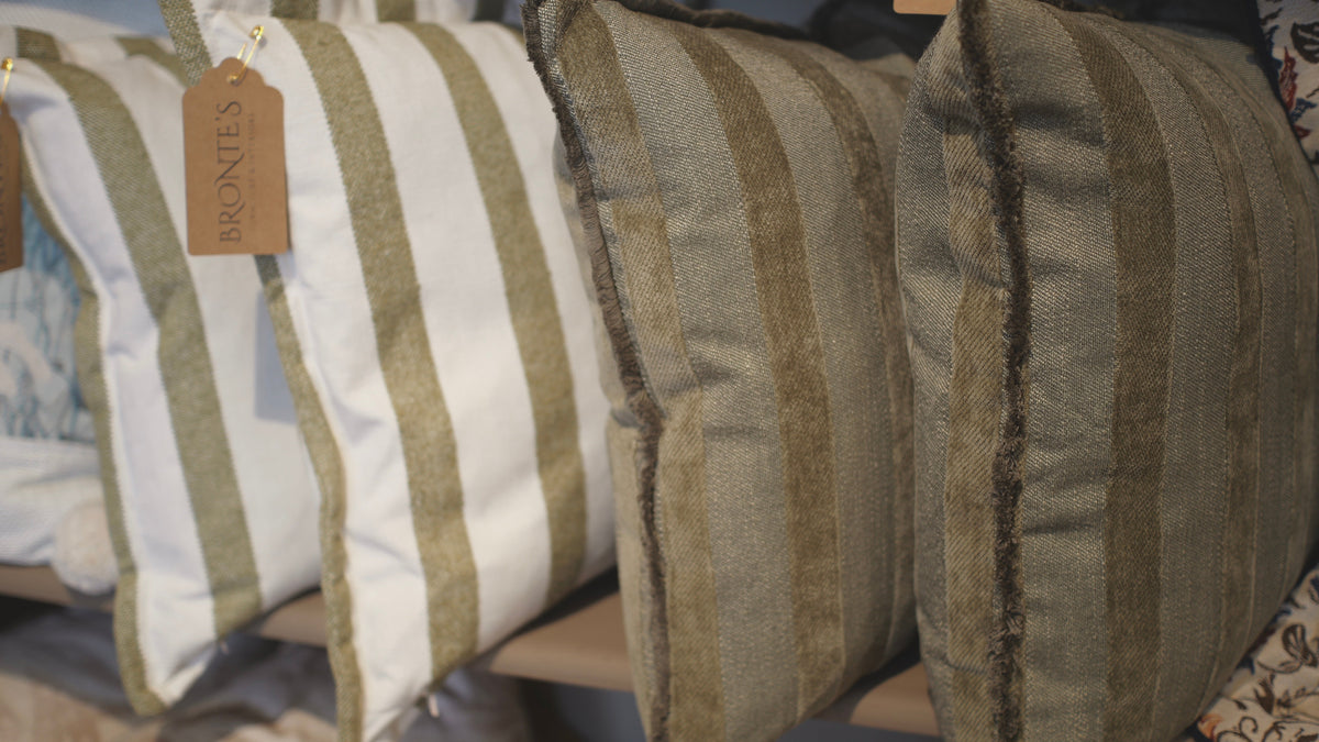 Striped cushions with a visible brand tag on a soft focus background