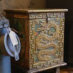 Decorative wooden chest with dragon design on a wooden floor.