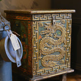 Decorative wooden chest with dragon design on a wooden floor.