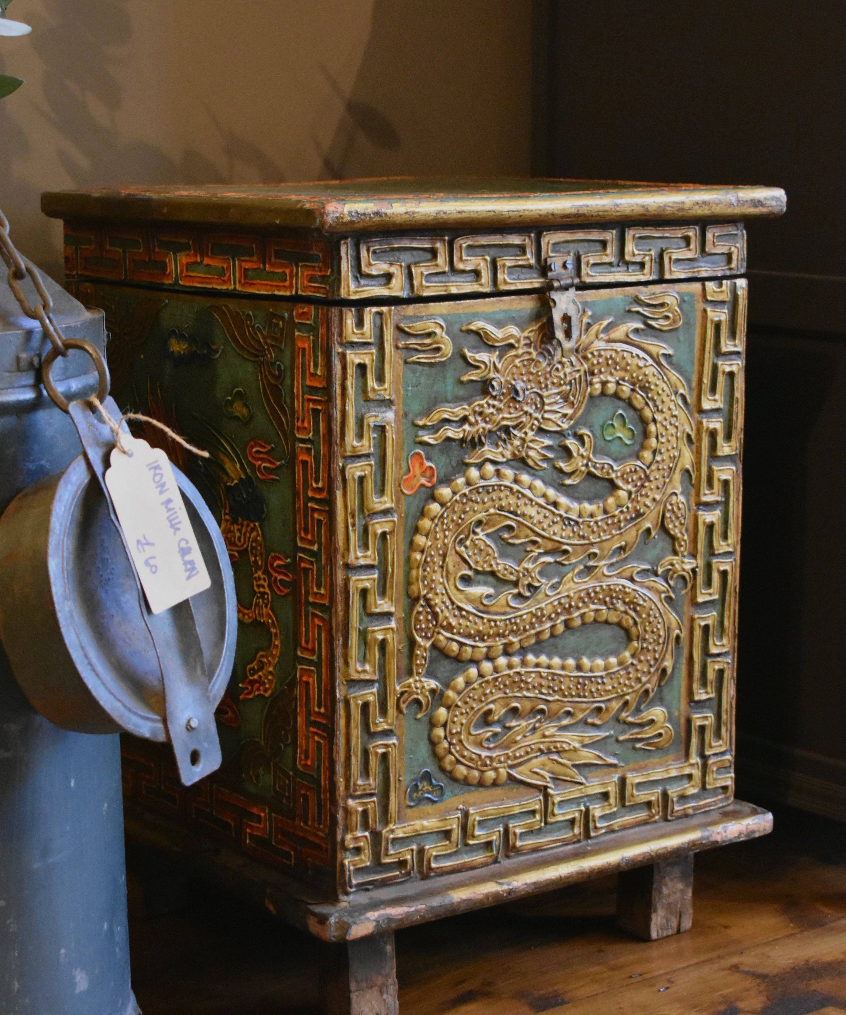 Decorative wooden chest with dragon design on a wooden floor.