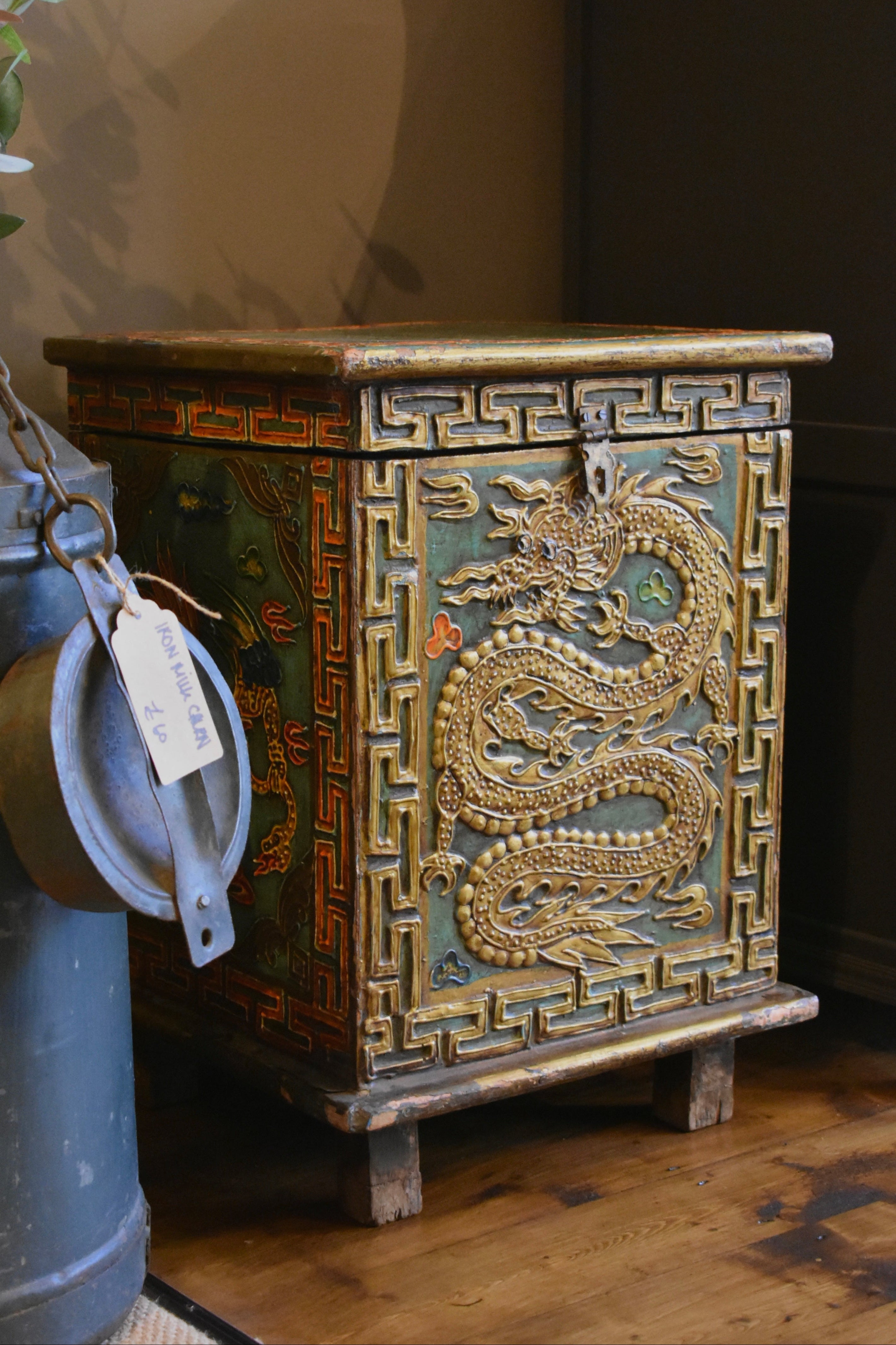Decorative wooden chest with dragon design on a wooden floor.