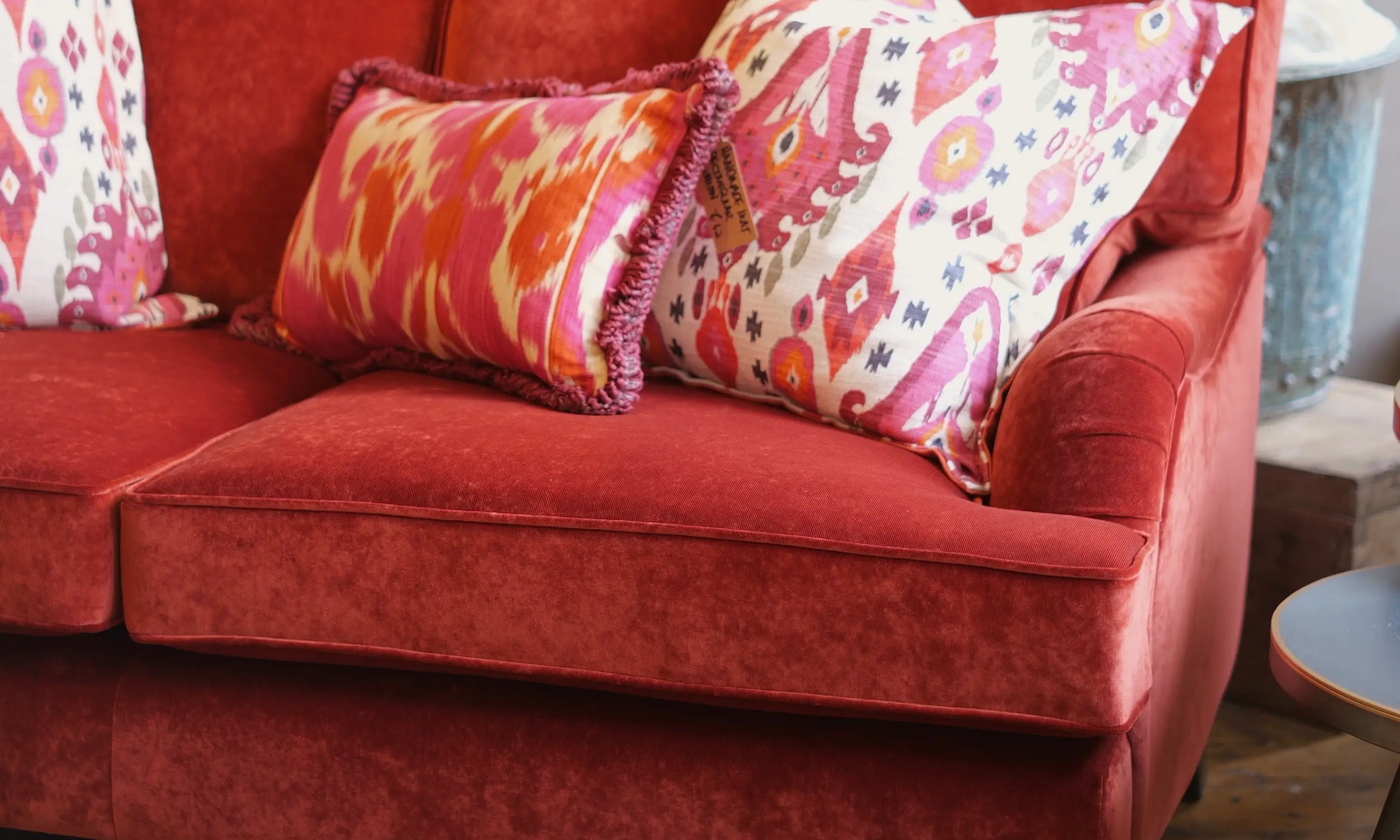 Red sofa with colorful pillows in a room setting