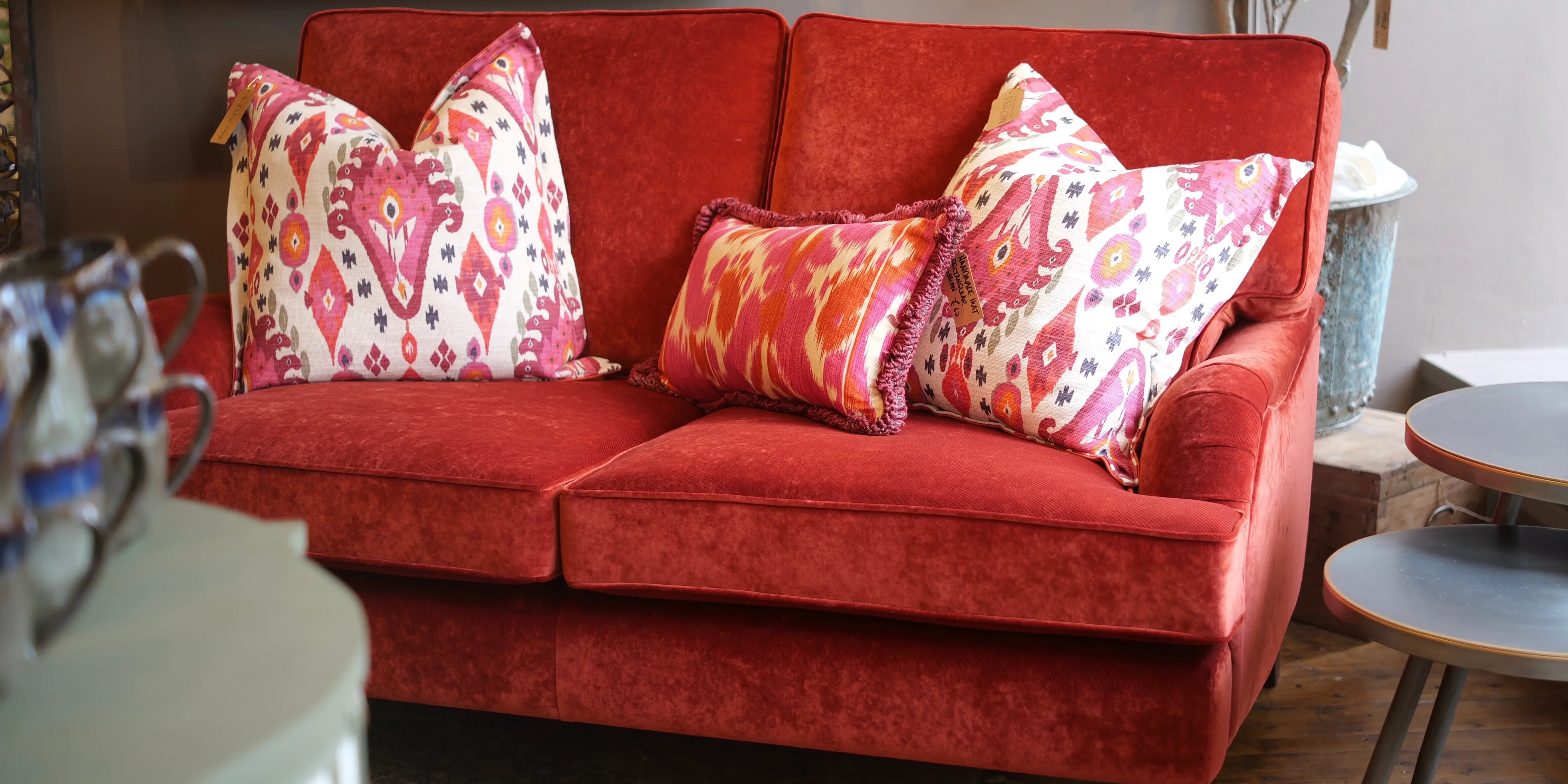 Red sofa with patterned cushions in a living room setting