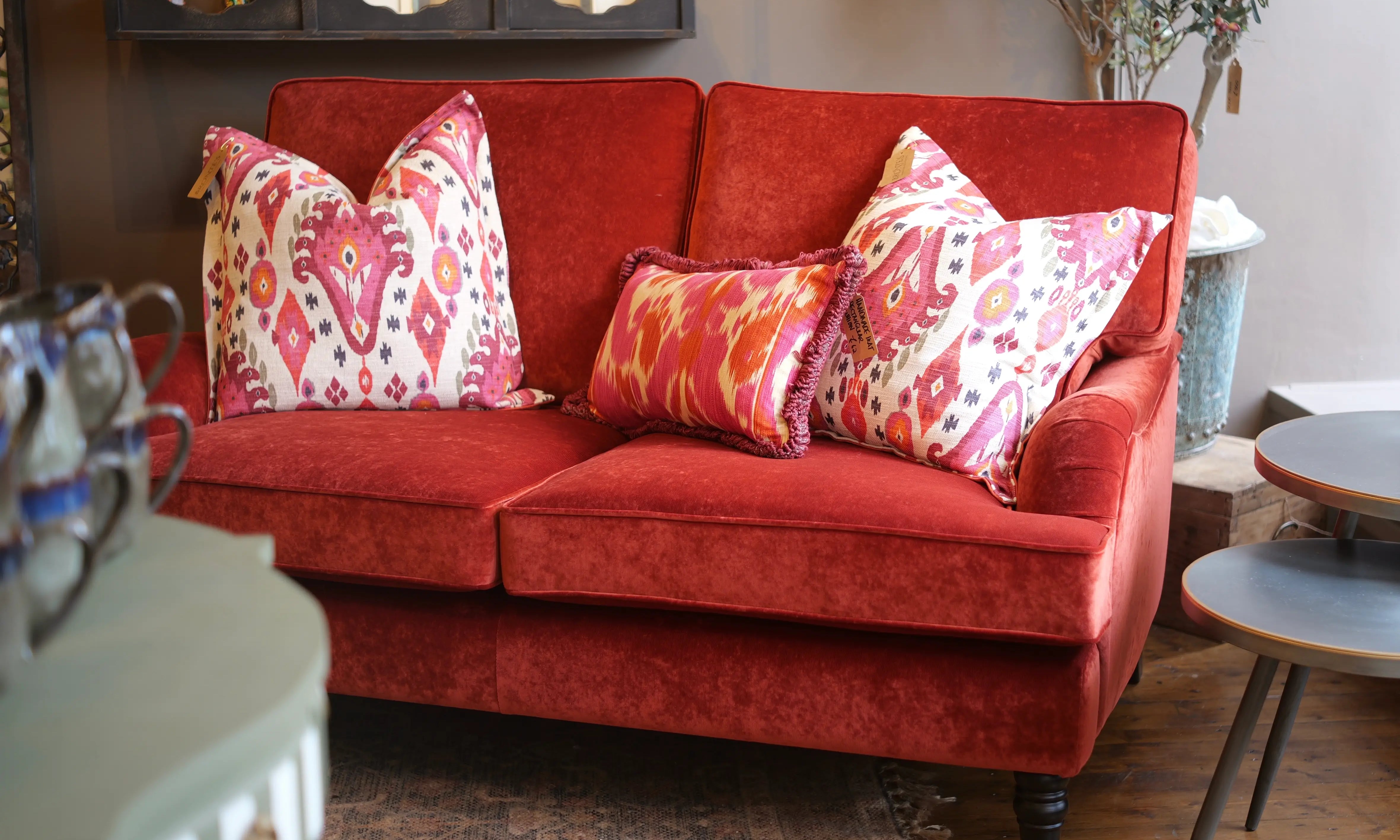 Red sofa with patterned cushions in a living room setting