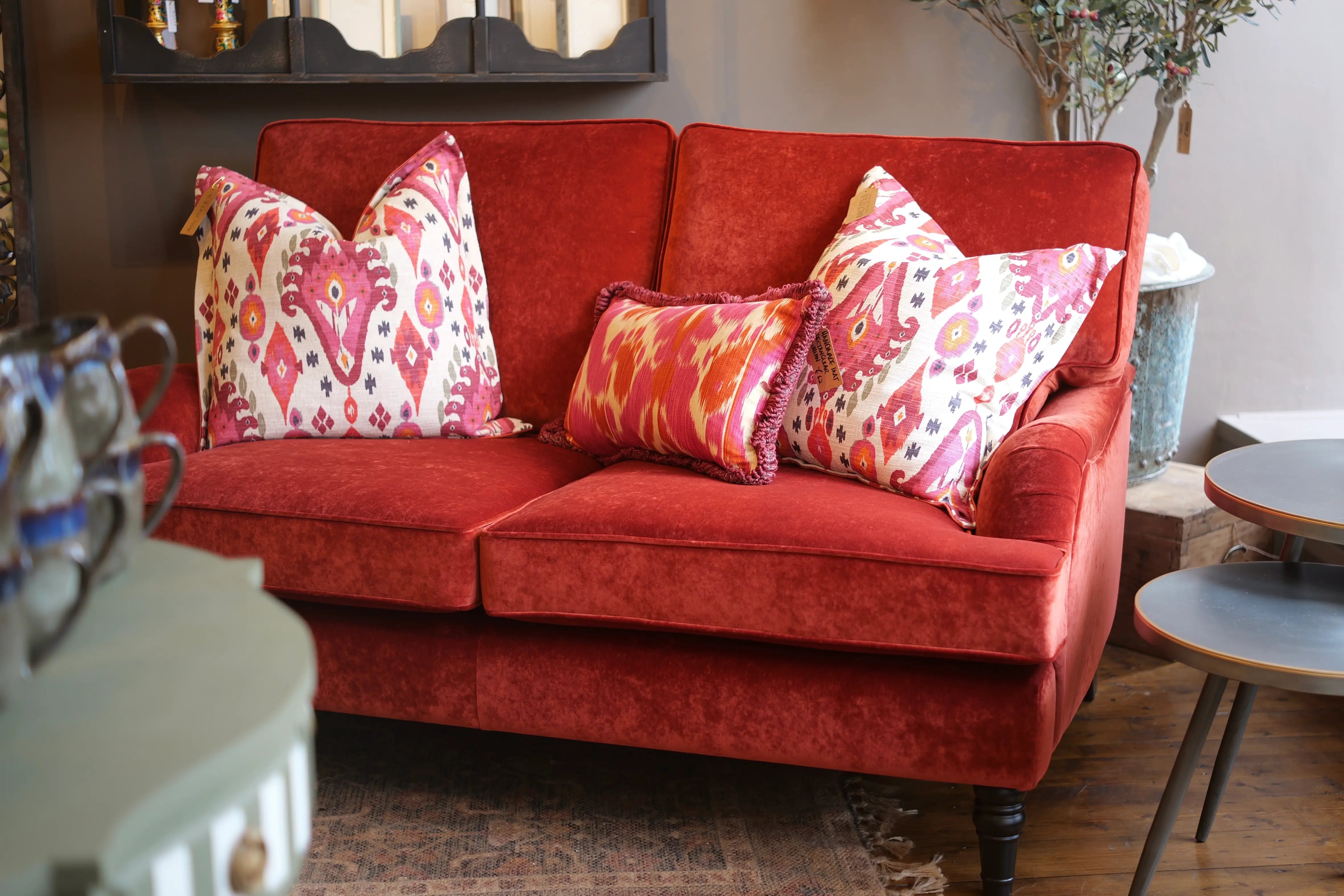Red sofa with patterned cushions in a living room setting
