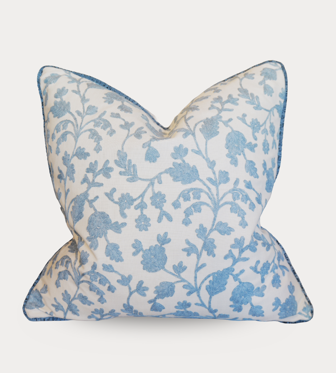Decorative pillow with blue floral pattern on a white background