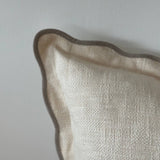 Close-up of a textured beige pillow against a light gray background