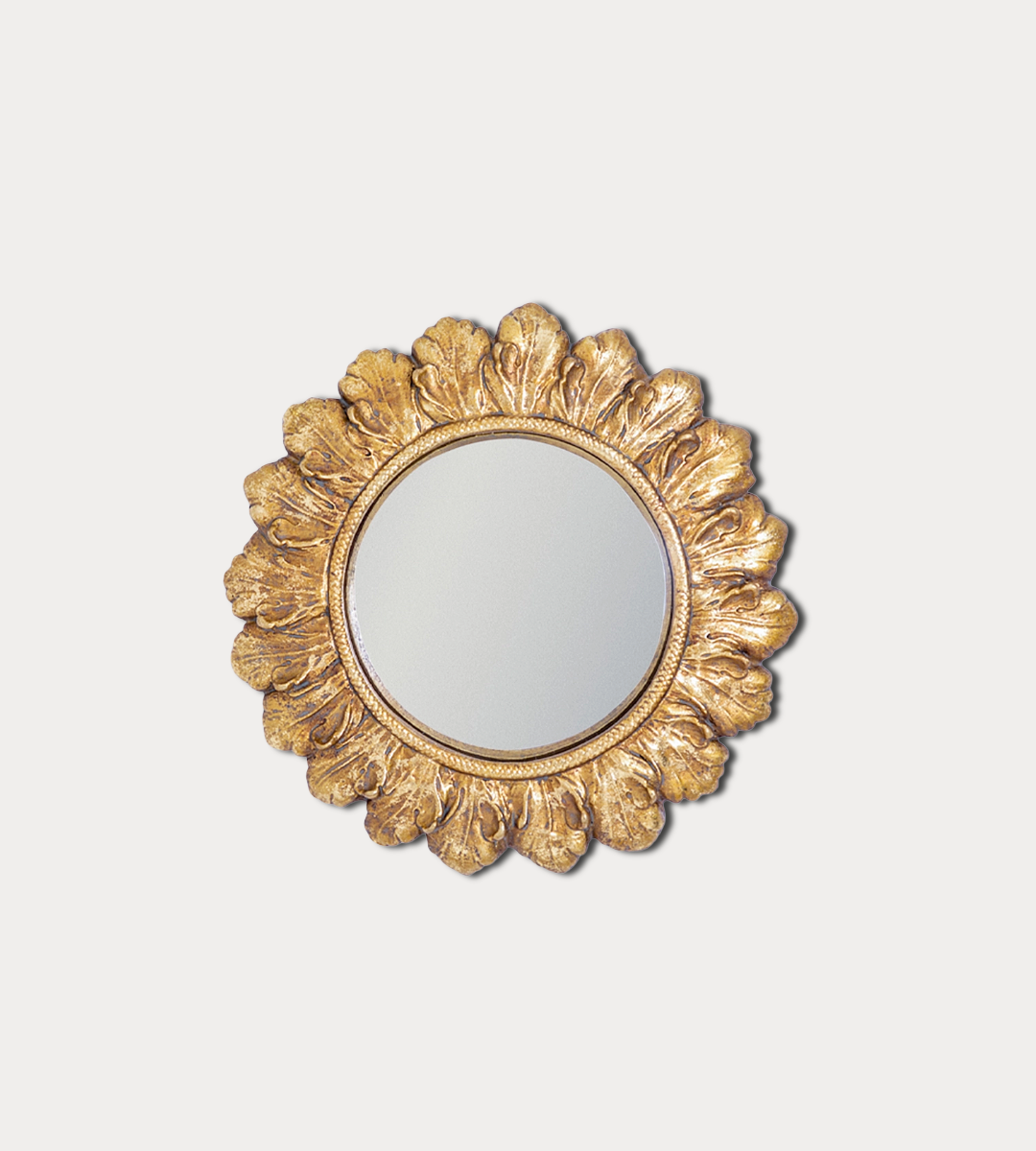 Decorative gold mirror with a floral frame on a light gray background