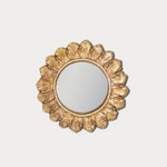 Decorative gold mirror with a floral frame on a light gray background