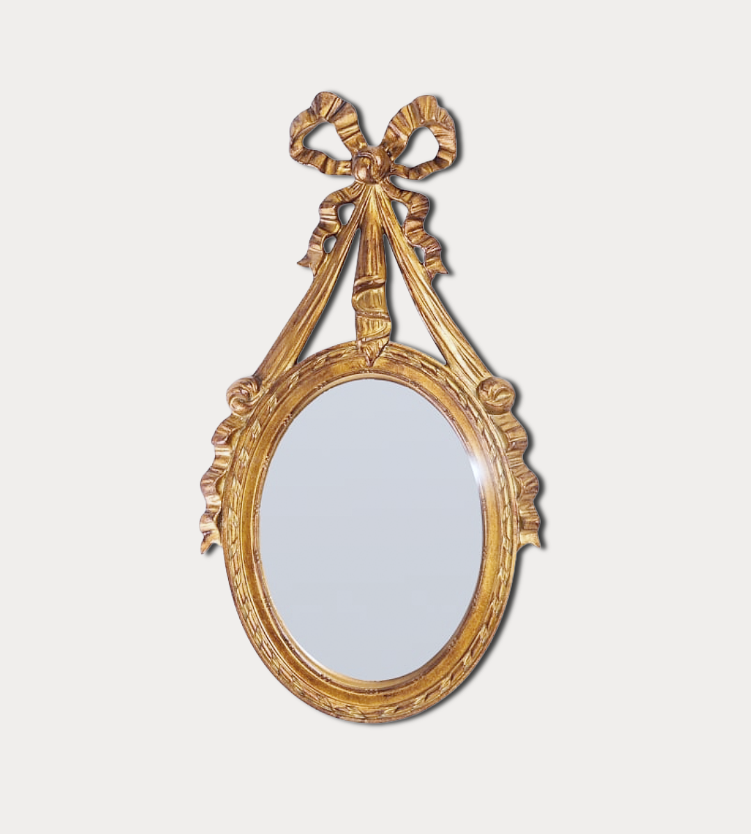 Decorative gold mirror with a bow-like design on a white background