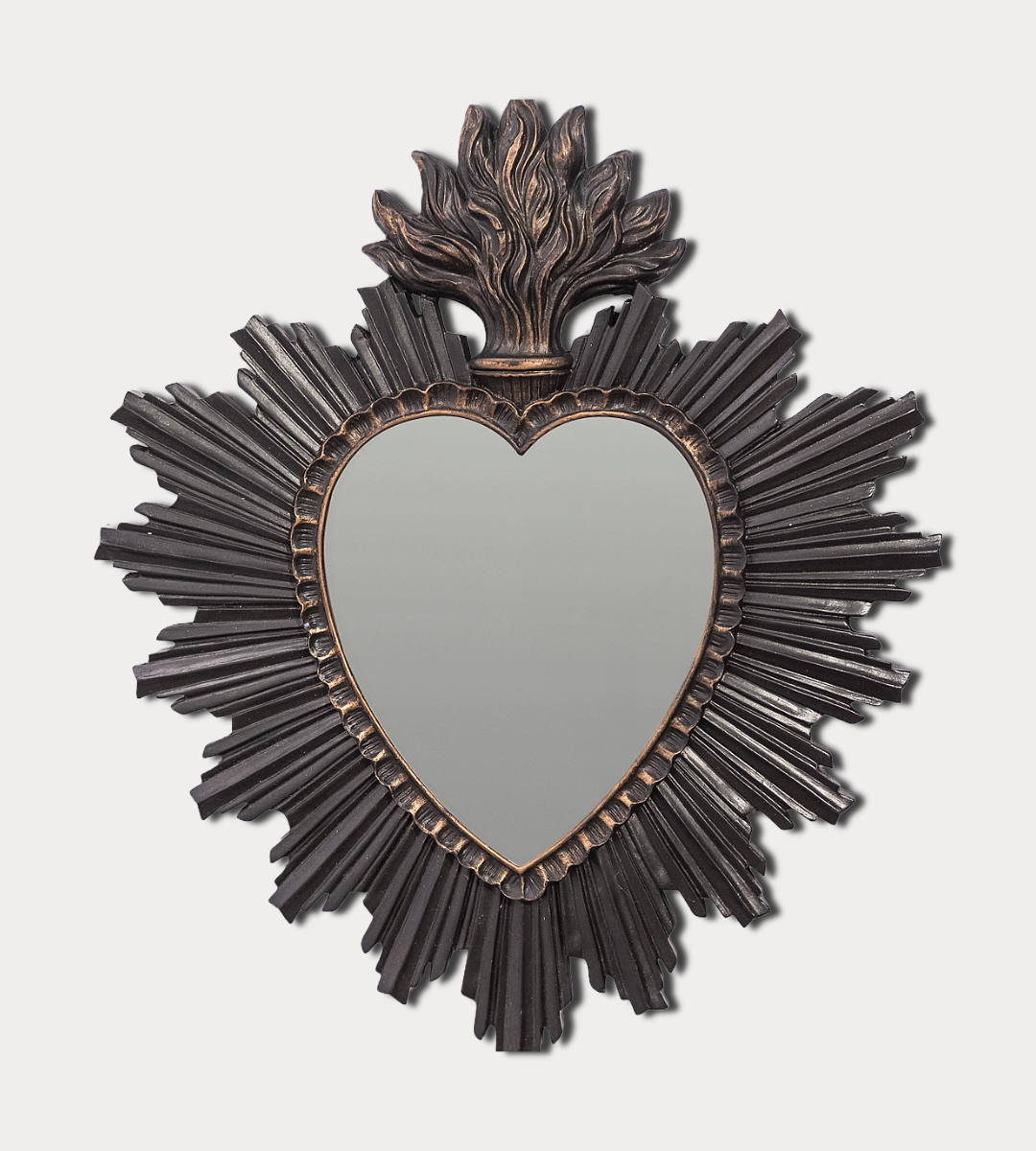 Decorative wall mirror with heart shape and sunburst frame on a light gray background