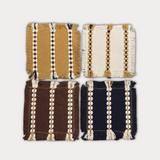 Four square woven textile swatches arranged in a 2x2 grid on a light gray background. The top-left swatch is mustard yellow with cream and black stripes; the top-right is off-white with cream and mustard stripes; the bottom-left is dark brown with cream and mustard stripes; the bottom-right is dark navy blue with cream and mustard stripes.