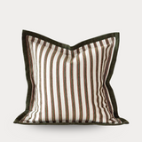 Striped pillow with brown and white pattern on a light gray background