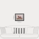 Framed artwork of a horse on a wall above a sofa with dimensions displayed.
