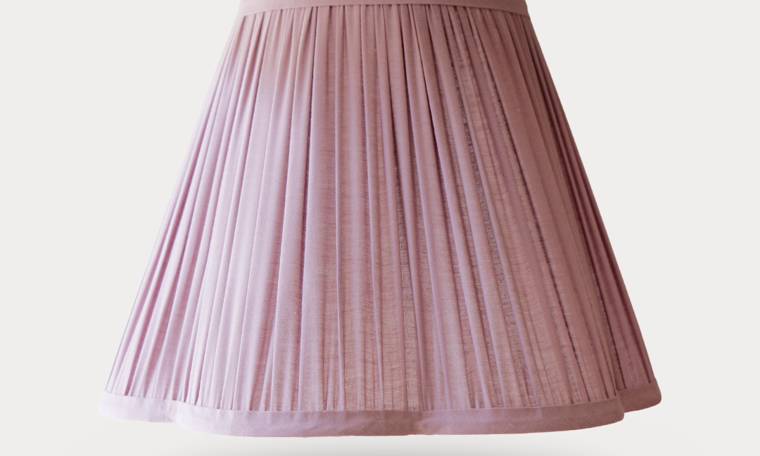 Pink pleated lampshade on a light gray background