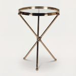 Small round table with a metallic gold base on a white background