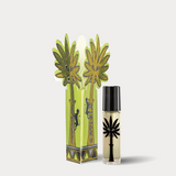 Perfume bottle with palm tree design and decorative packaging on a white background