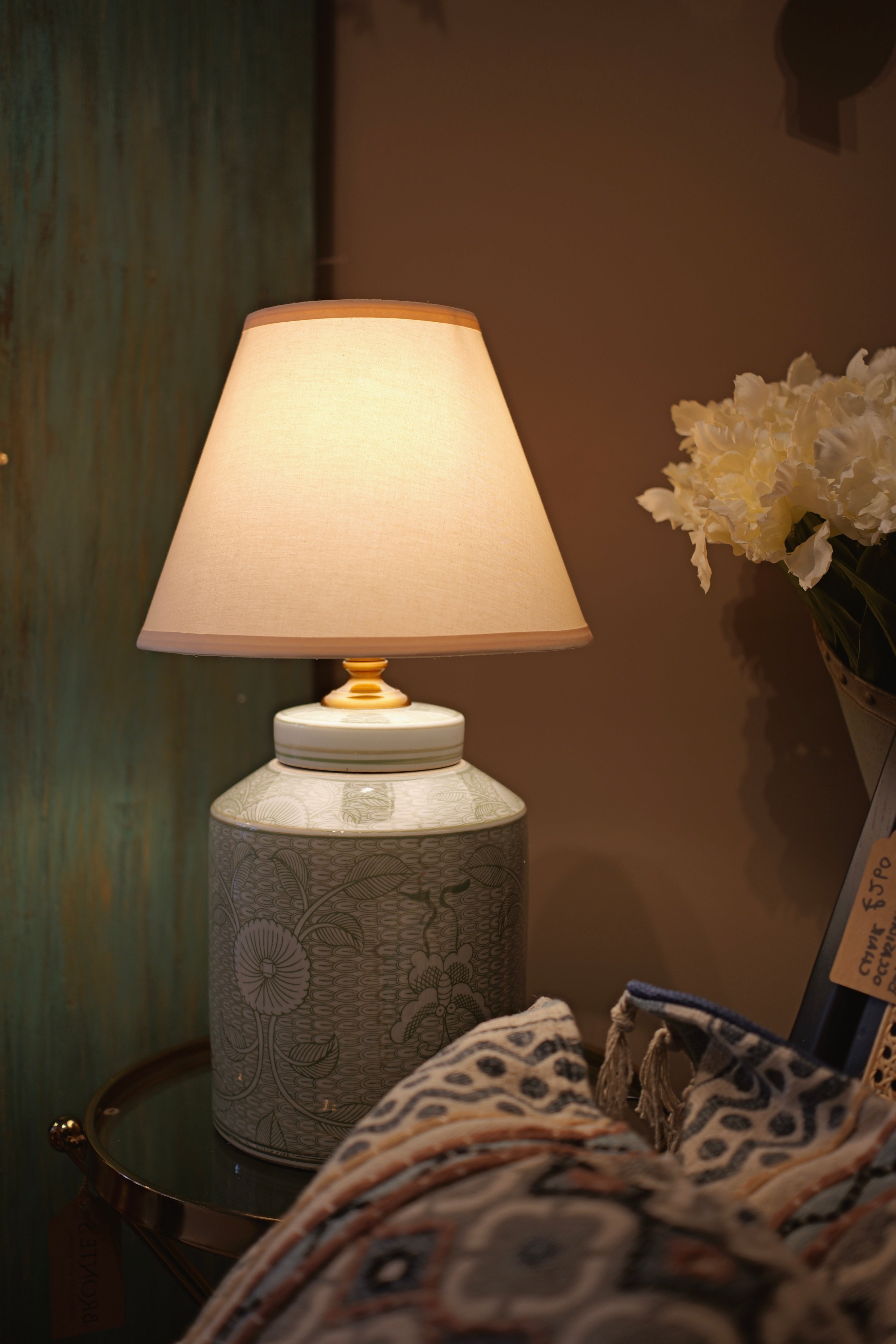 Decorative lamp with a textured base on a table against a neutral wall.