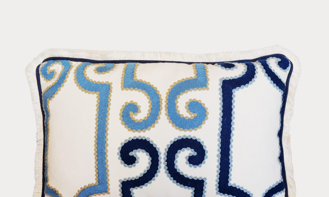 Decorative pillow with blue and navy pattern on a white background