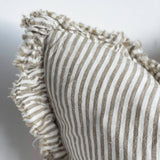 Textured pillow with striped pattern and ruffled edge on a neutral background