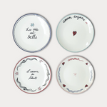 Four decorative plates with French phrases on a white background