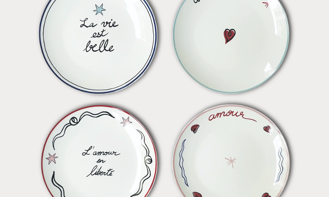 Four decorative plates with French phrases on a white background