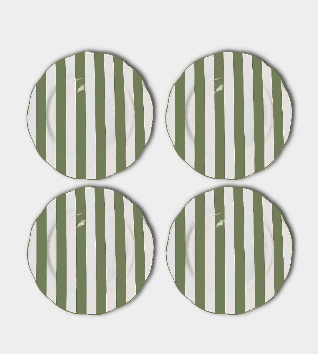 Four green and white striped plates on a light gray background