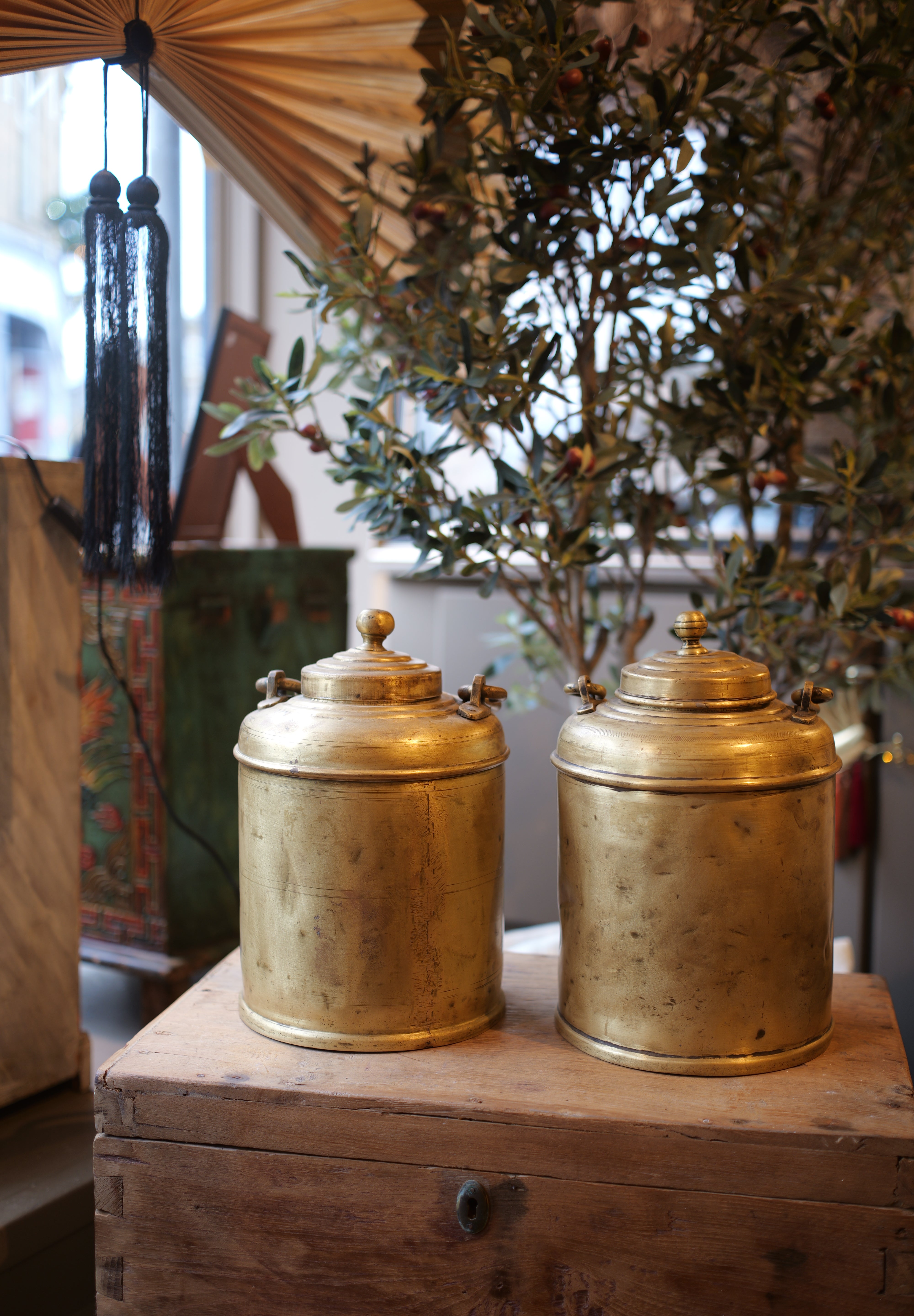 Two gold cylindrical objects on a wooden surface with a blurred background