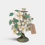 Decorative metal tree with flowers and a tag on a white background
