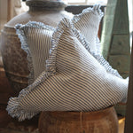 Decorative pillow with ruffled edges on a wooden surface
