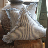 Decorative pillow with ruffled edges on a wooden surface
