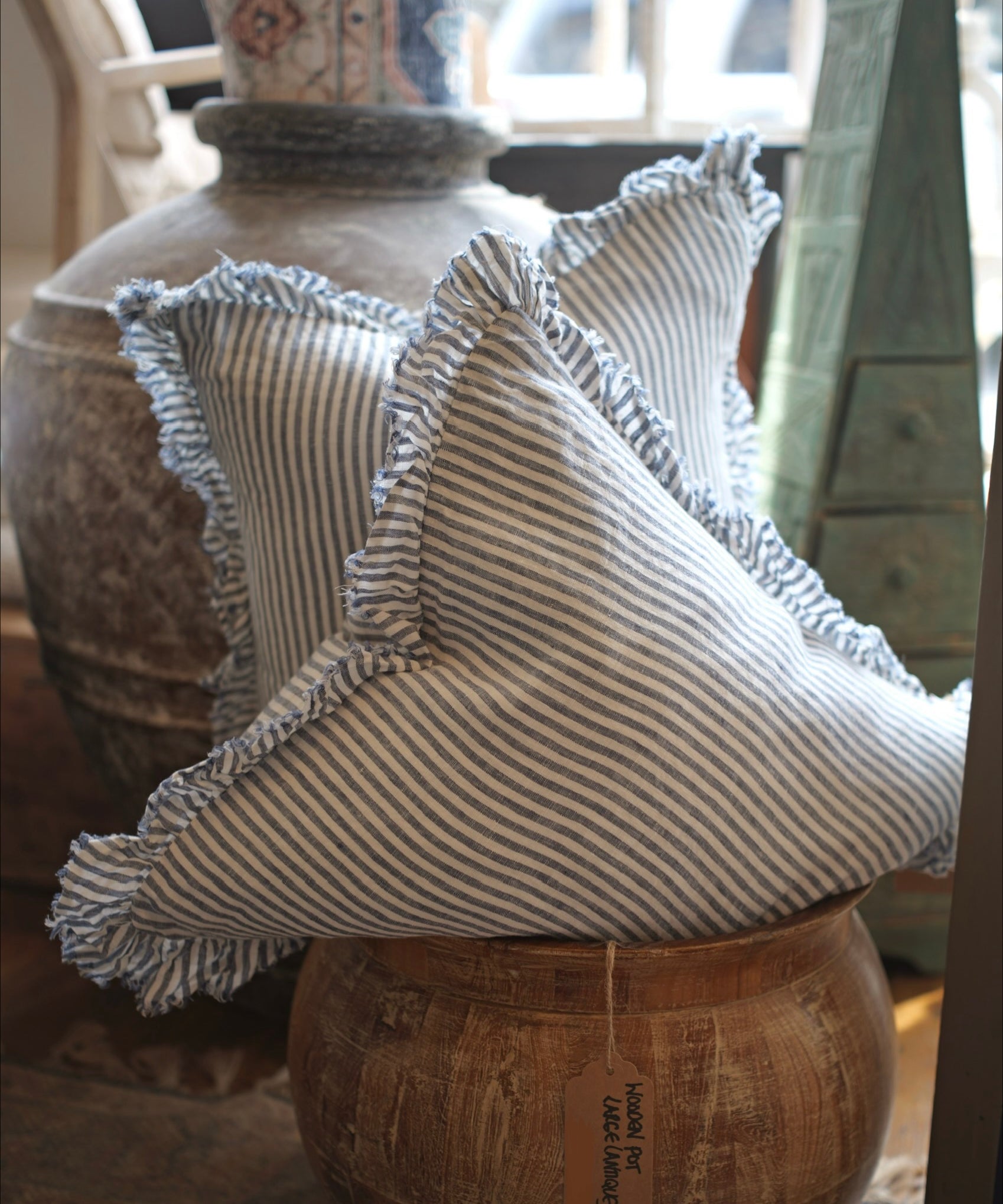 Decorative pillow with ruffled edges on a wooden surface