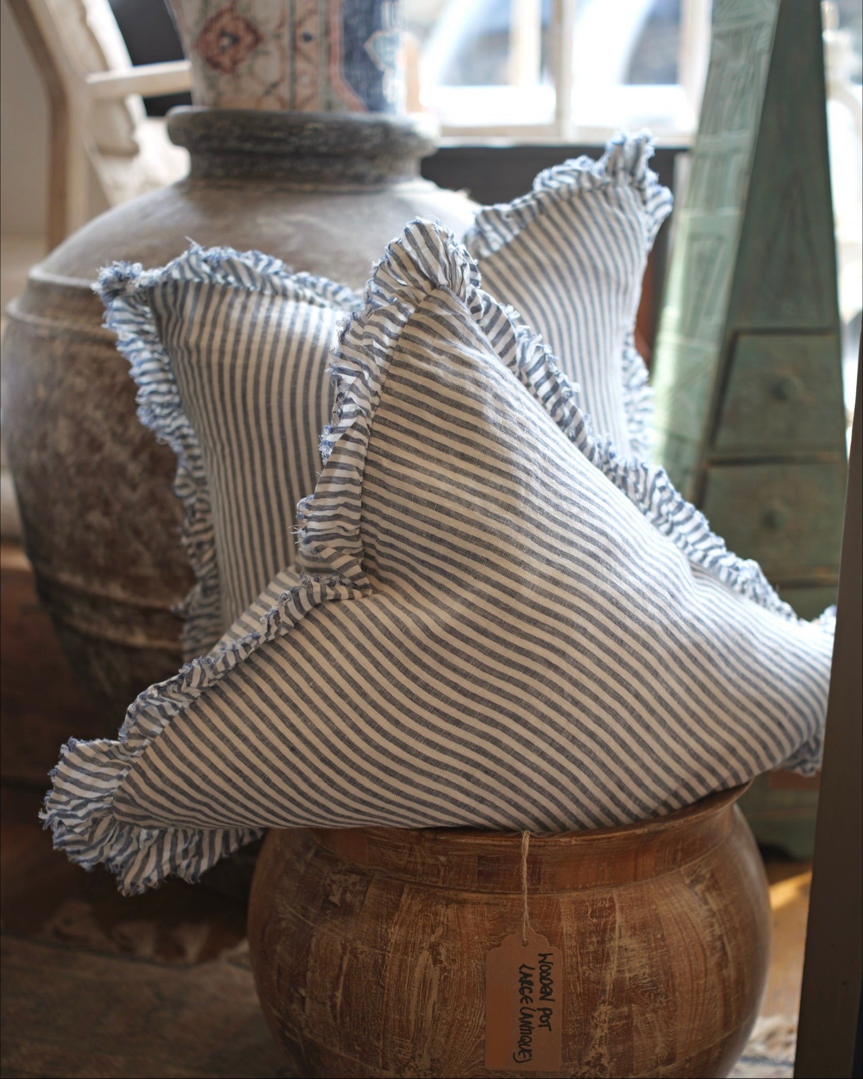 Decorative pillow with ruffled edges on a wooden surface