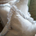 Close-up of a striped fabric with ruffled edges on a wooden surface.