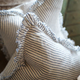 Close-up of a striped fabric with ruffled edges on a wooden surface.