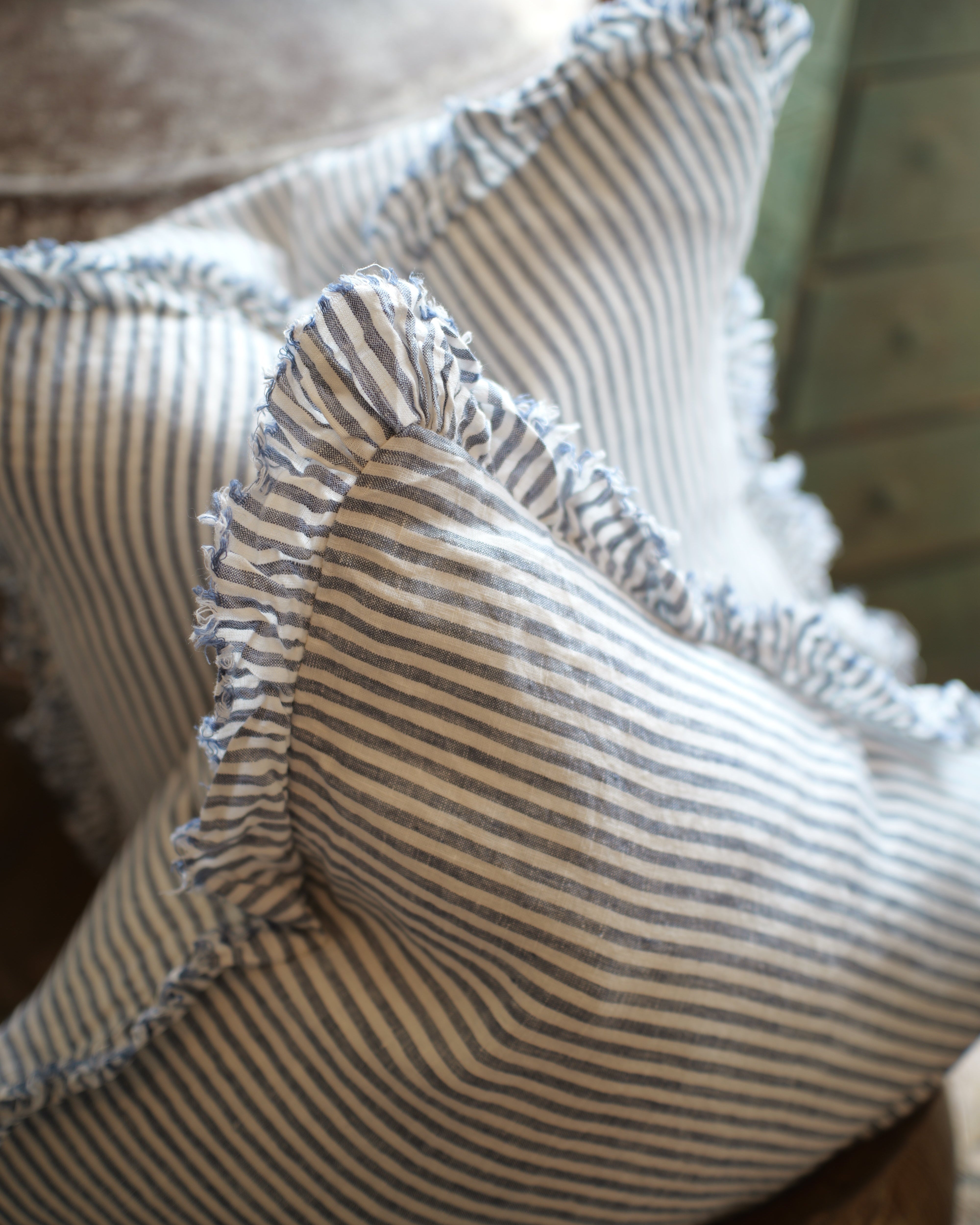 Close-up of a striped fabric with ruffled edges on a wooden surface.