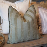 Textured pillow on a wooden surface with neutral tones