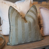 Textured pillow on a wooden surface with neutral tones