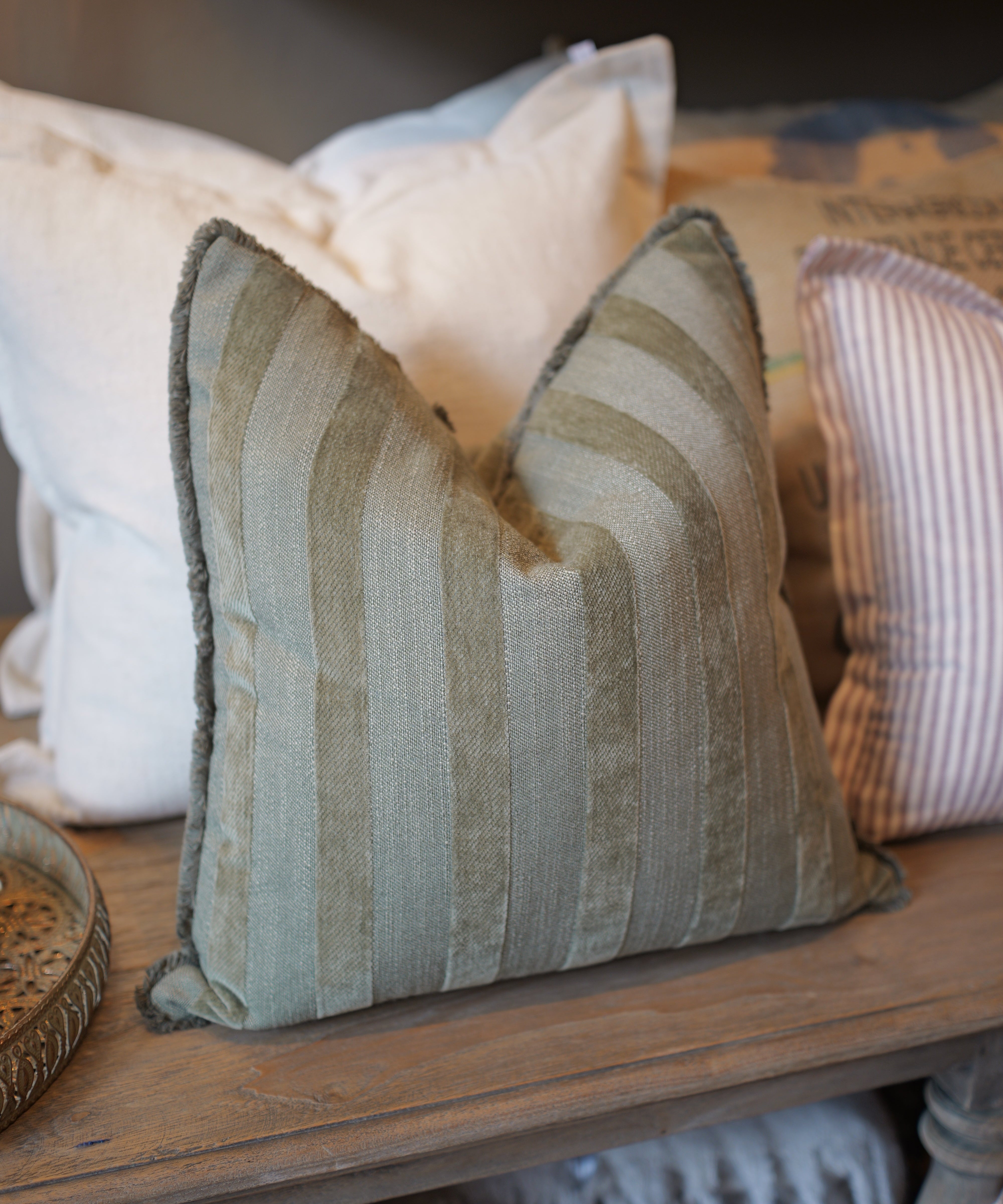 Textured pillow on a wooden surface with neutral tones
