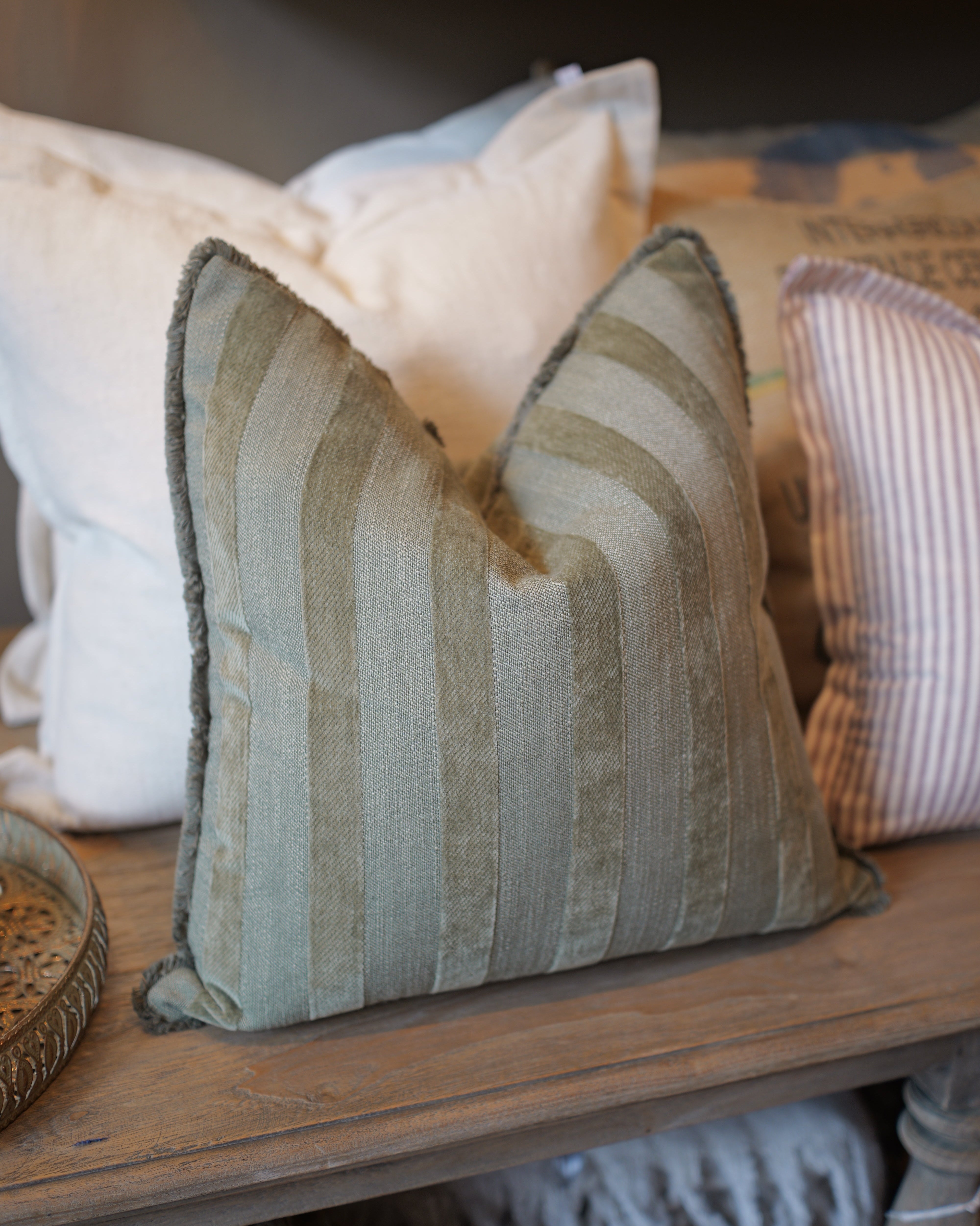 Textured pillow on a wooden surface with neutral tones