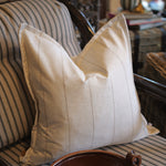 Beige pillow on a striped sofa with a blurred background