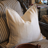 Beige pillow on a striped sofa with a blurred background