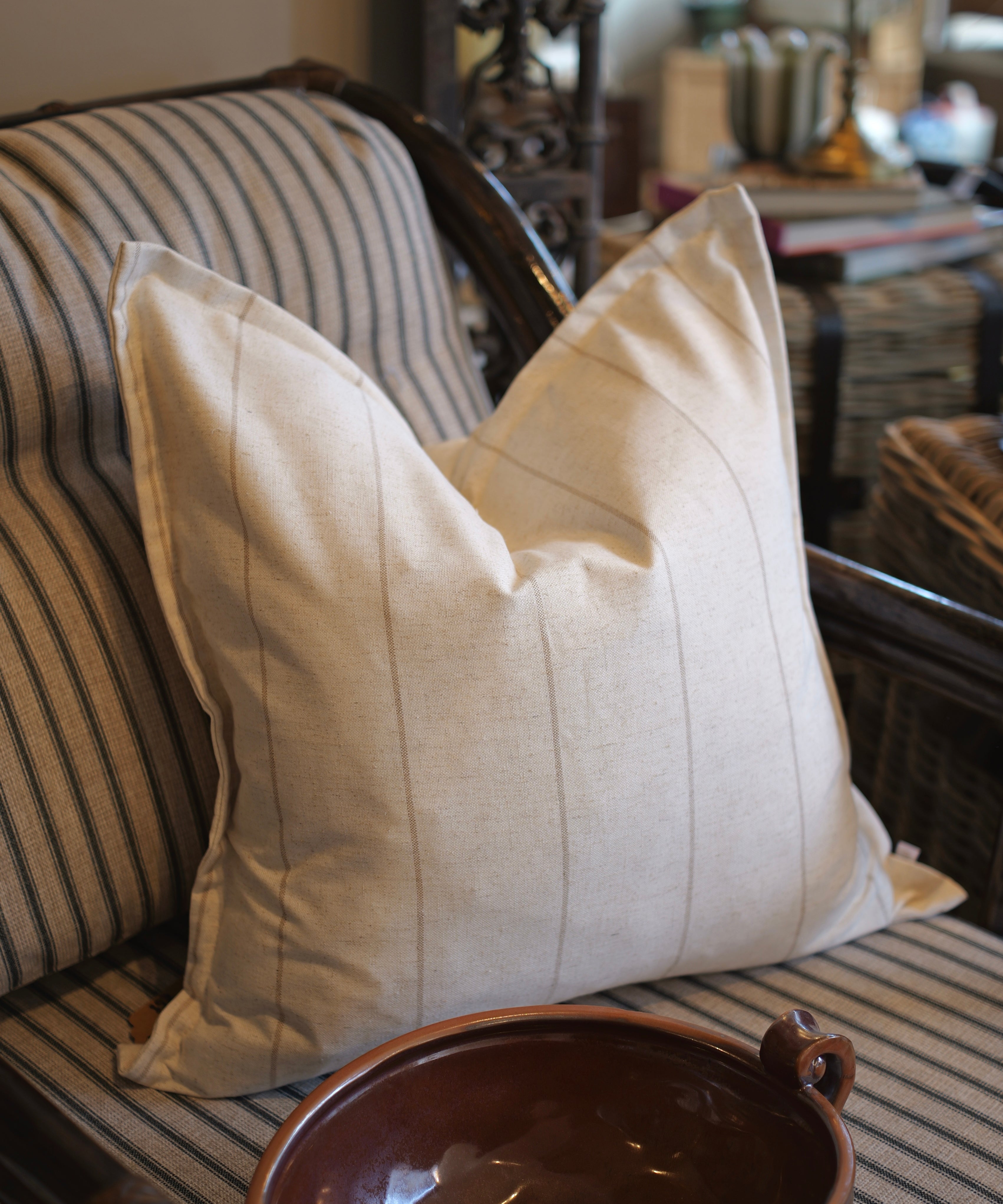 Beige pillow on a striped sofa with a blurred background