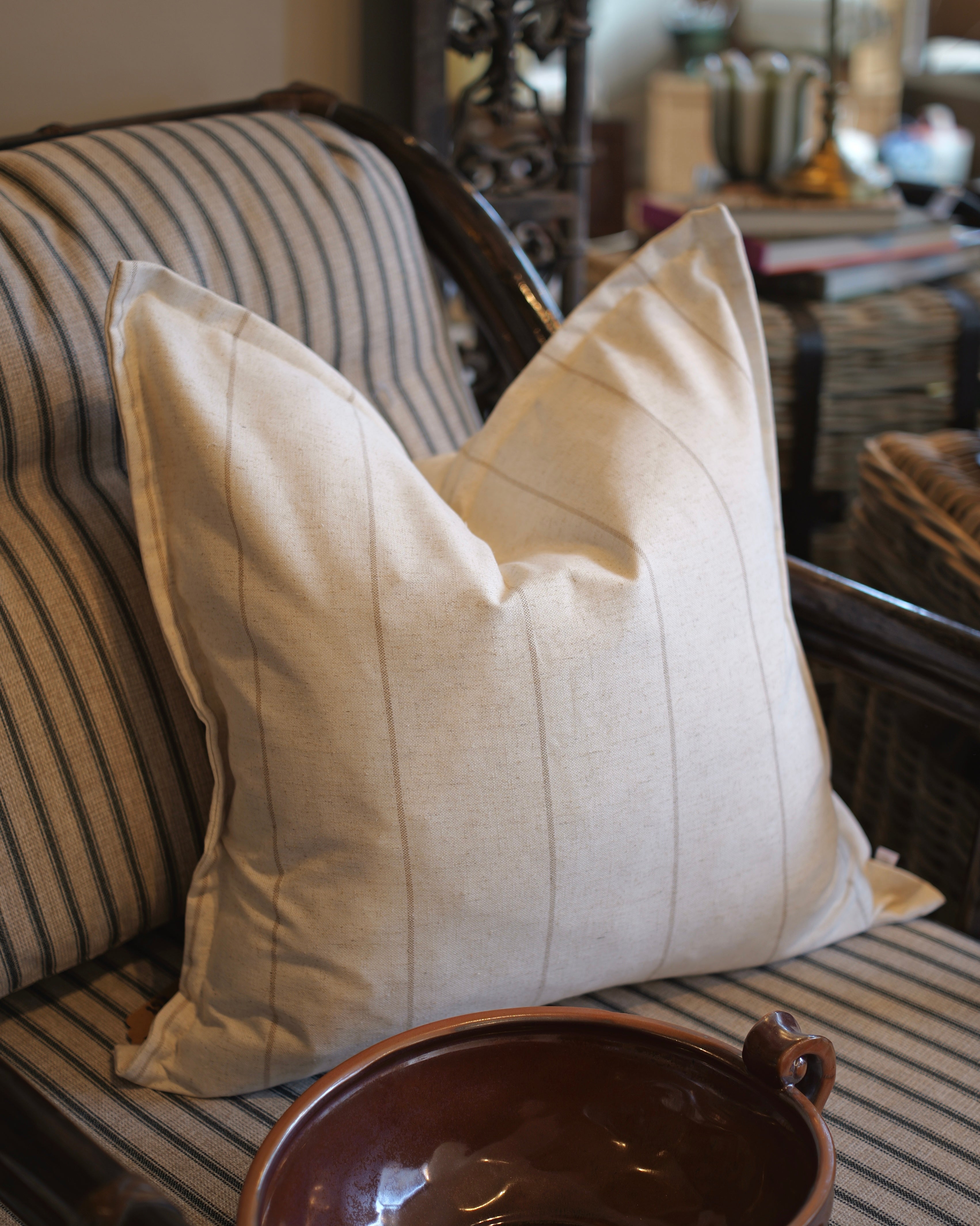 Beige pillow on a striped sofa with a blurred background