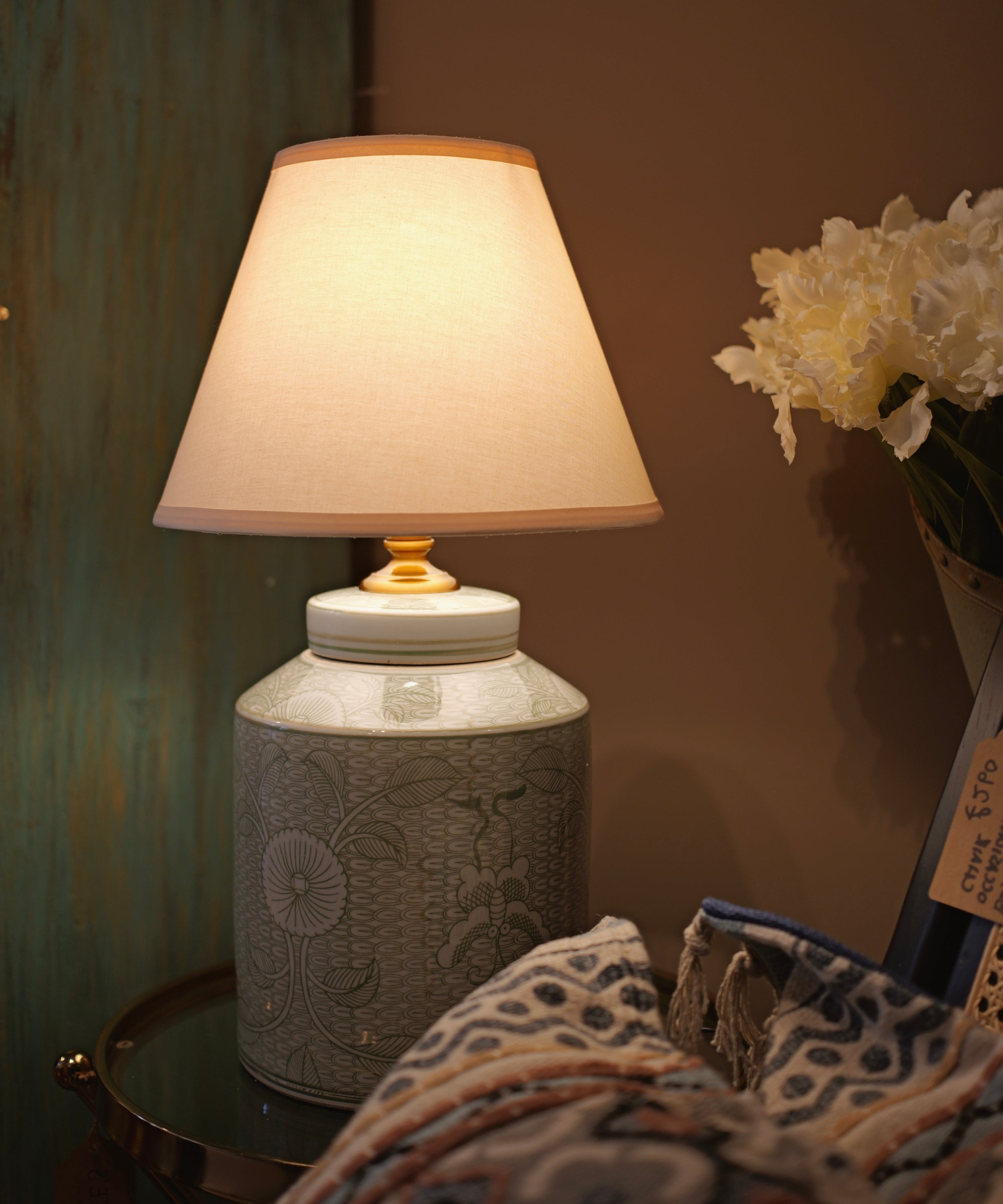 Decorative lamp with a textured base on a table against a neutral wall.