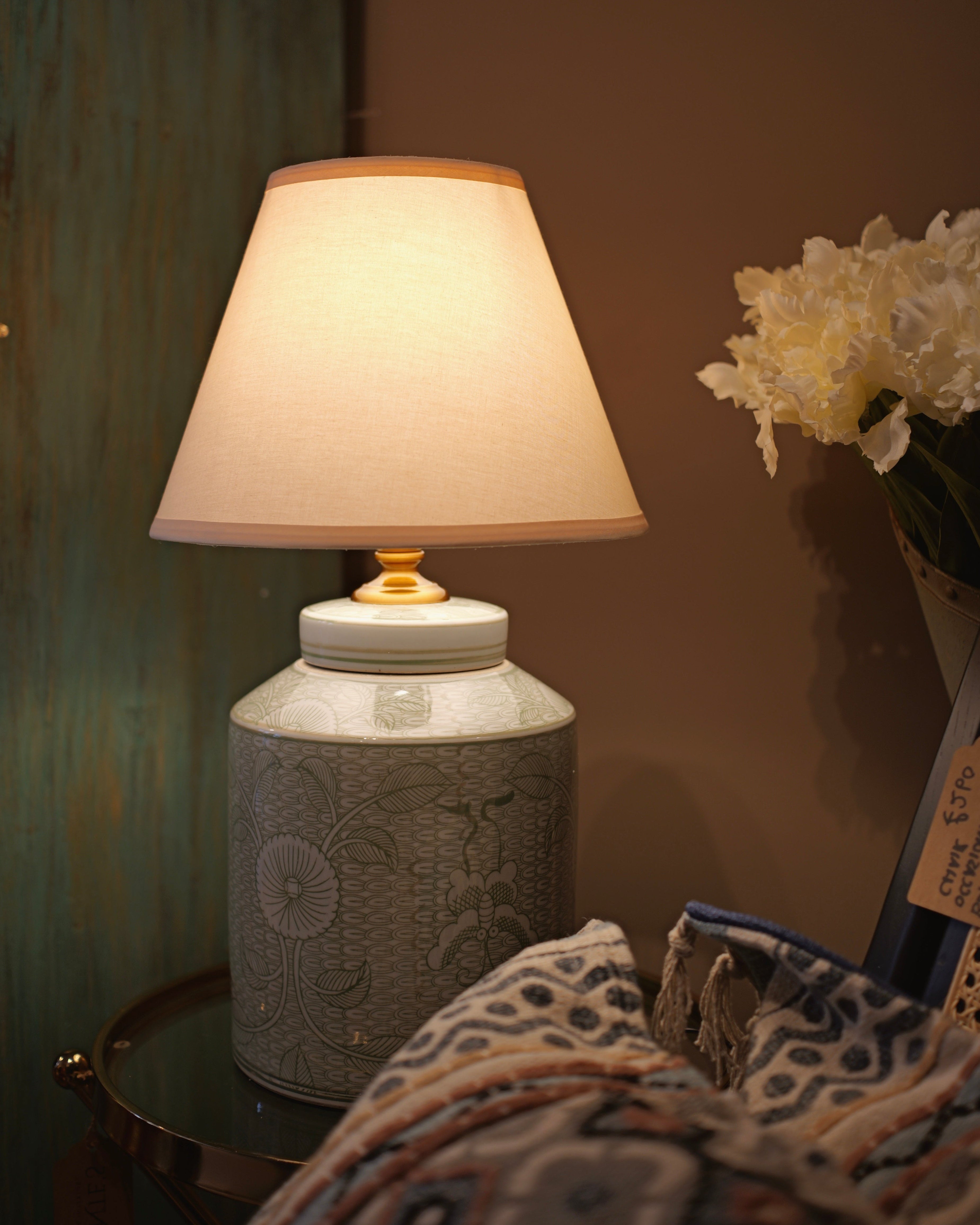 Decorative lamp with a textured base on a table against a neutral wall.