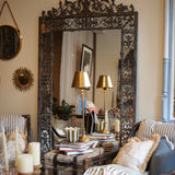 Living room with ornate mirror, striped sofa, and decorative pillows.
