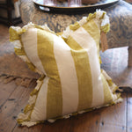 Striped pillow with ruffled edges on a wooden floor