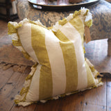 Striped pillow with ruffled edges on a wooden floor