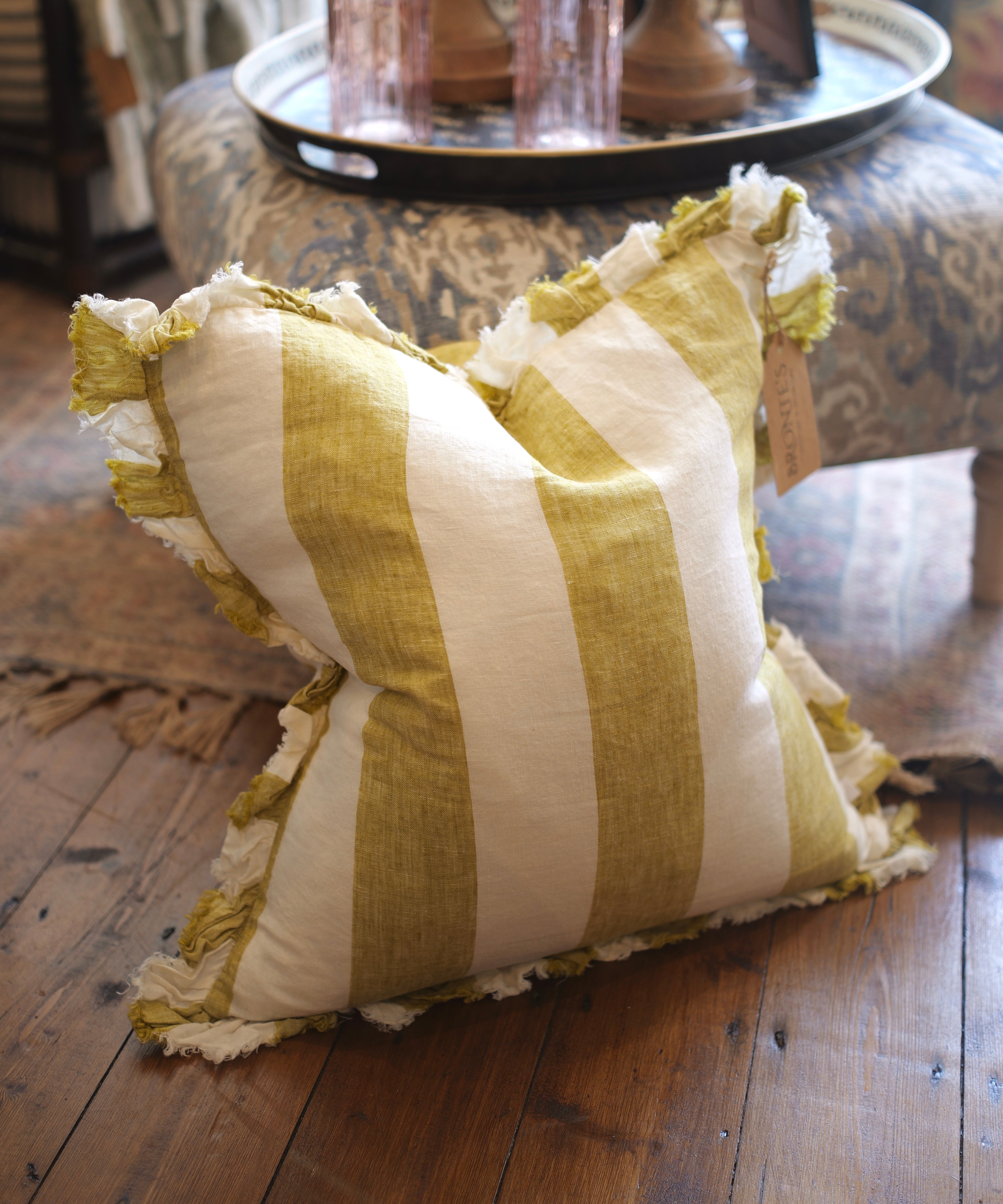 Striped pillow with ruffled edges on a wooden floor